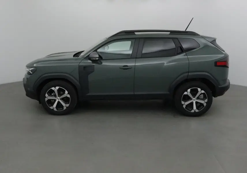 Profil côté gauche du Dacia Duster 2025 en kaki lichen, avec jantes alliage et toit noir contrasté.