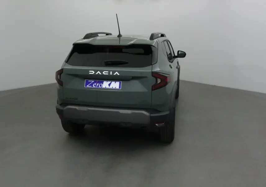 Vue arrière d'un Dacia Duster 2025 kaki lichen avec feux arrière en forme de C et toit équipé de barres de toit noires.