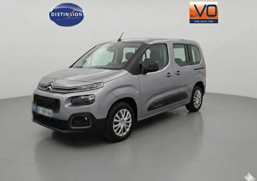 Citroën Berlingo gris clair en 3/4 avant droit, avec protections noires latérales et jantes alliage.