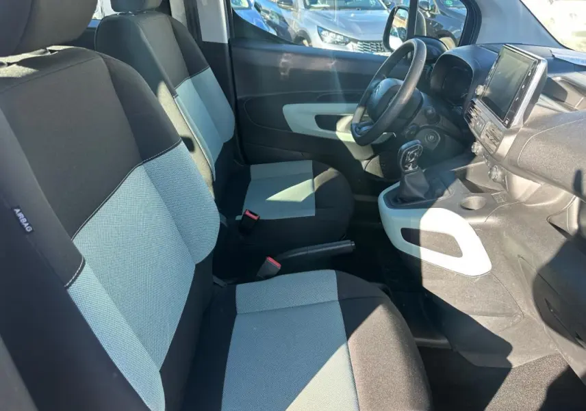 Vue intérieure côté gauche du Citroën Berlingo 2020, sièges bicolores noirs et gris, tableau de bord avec écran tactile.