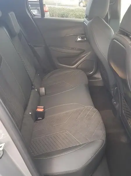 Vue intérieure côté droit des sièges arrière gris de la Peugeot 208 Hybrid 110 e-DCS6 GT 2025 avec finitions en tissu et cuir.