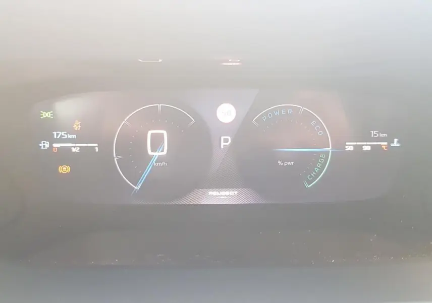 Affichage numérique du tableau de bord de la Peugeot 208 Hybrid 110 gris, montrant vitesse et indicateurs énergie.