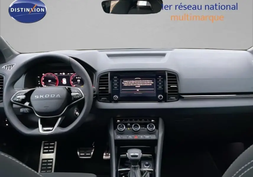 Intérieur noir du Skoda Karoq 2025, vue frontale du tableau de bord avec écran tactile et volant multifonctions.