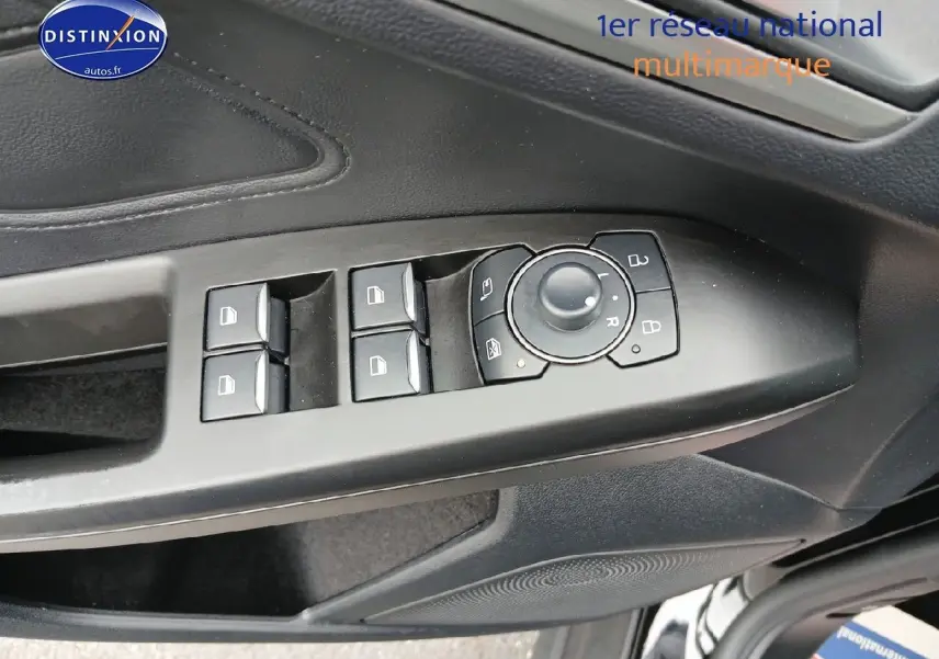 Gros plan sur la commande des vitres et rétroviseurs côté conducteur d'une Ford Focus noir Agate métallisé.