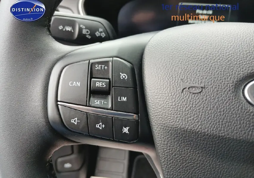 Gros plan sur les commandes multifonctions à gauche du volant cuir de la Ford Focus 2024 noir Agate métallisé.