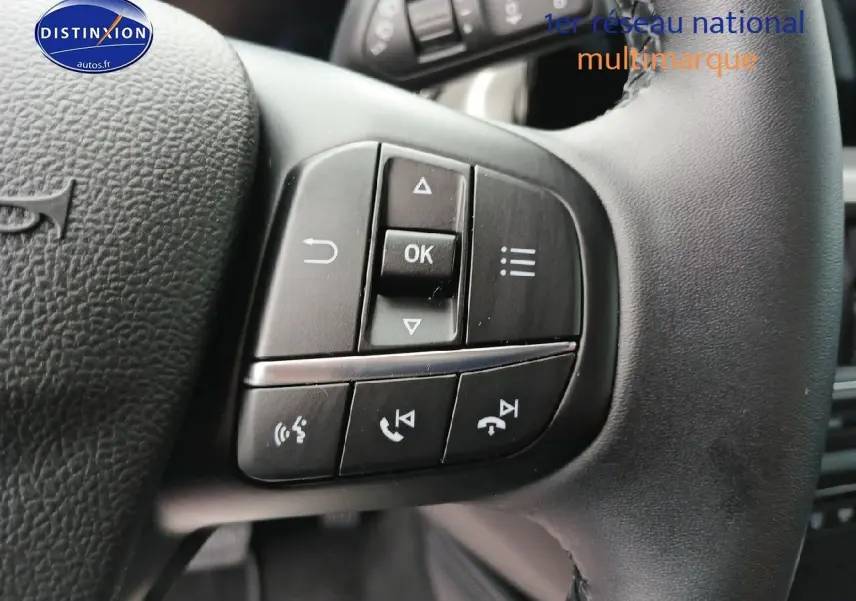 Gros plan sur les commandes multifonctions du volant cuir noir de la Ford Focus 2024 Titanium X Business.