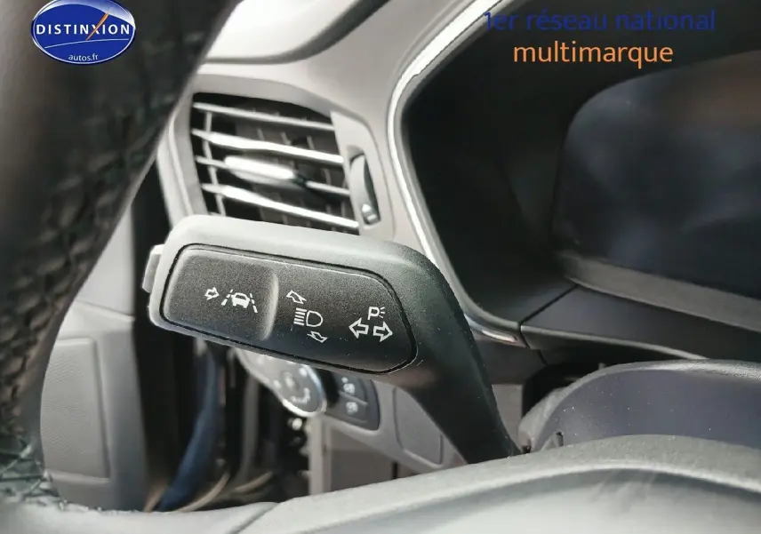 Gros plan sur la commande de clignotants et aides à la conduite dans l’habitacle d’une Ford Focus noire.