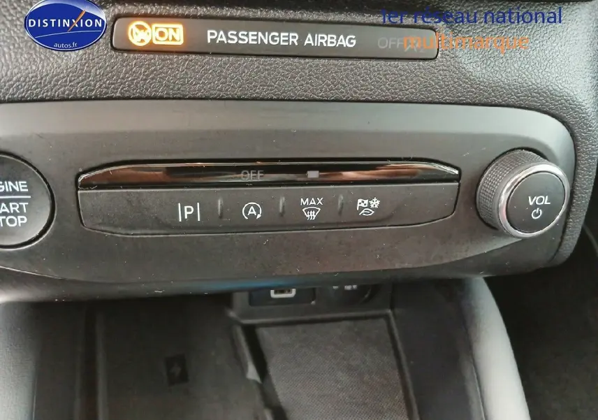 Détail du tableau de bord noir de la Ford Focus 2024 avec commandes climatisation et bouton volume audio.