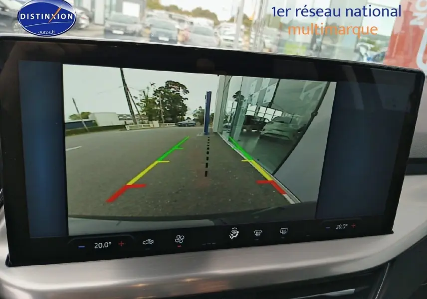Écran tactile montrant la caméra de recul d'une Ford Focus noire, vue arrière avec lignes de guidage colorées.