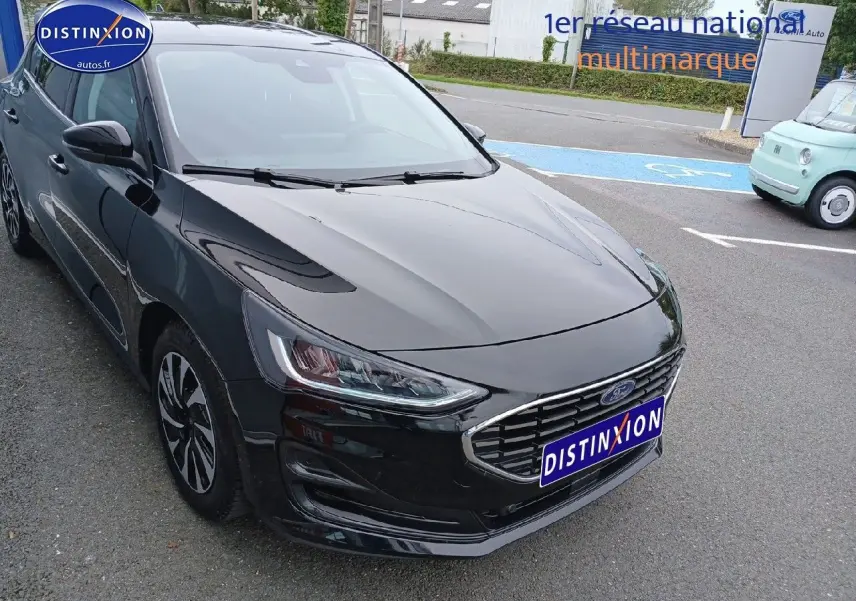 Ford Focus noir Agate métallisé vue 3/4 avant droit avec calandre chromée et phares LED.