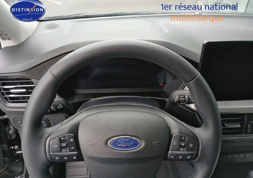 Vue rapprochée du volant cuir noir multifonction de la Ford Focus 2024, tableau de bord et écran tactile visibles.