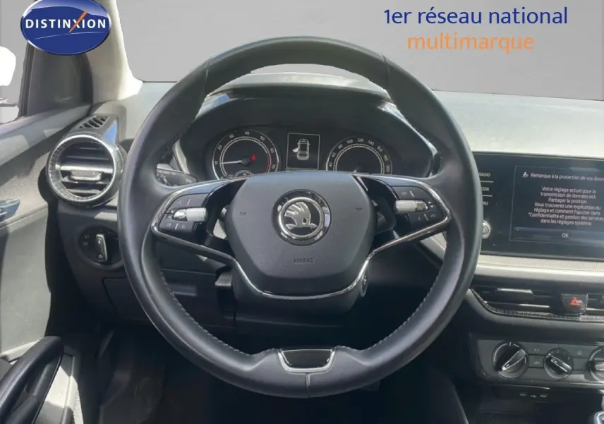 Vue intérieure centrée sur le volant cuir noir de la Skoda Fabia 2022 avec tableau de bord et écran multimédia visibles.
