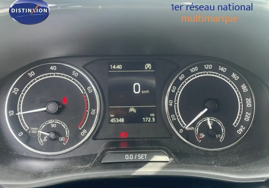 Vue rapprochée du tableau de bord de la Skoda Fabia blanc candy, affichant compteur et écran digital à l'arrêt.