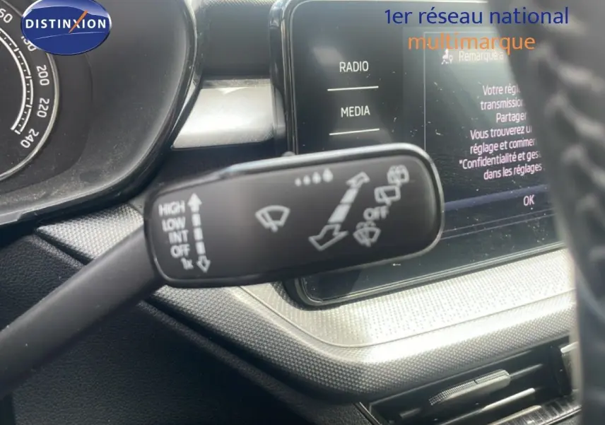 Gros plan sur la commande d’essuie-glace à gauche du volant dans l’habitacle d’une Skoda Fabia blanche 2022.