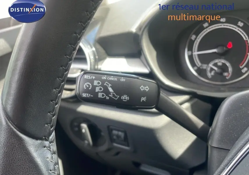 Gros plan sur le commodo gauche du volant d’une Skoda Fabia 2022, intérieur noir avec tableau de bord visible.