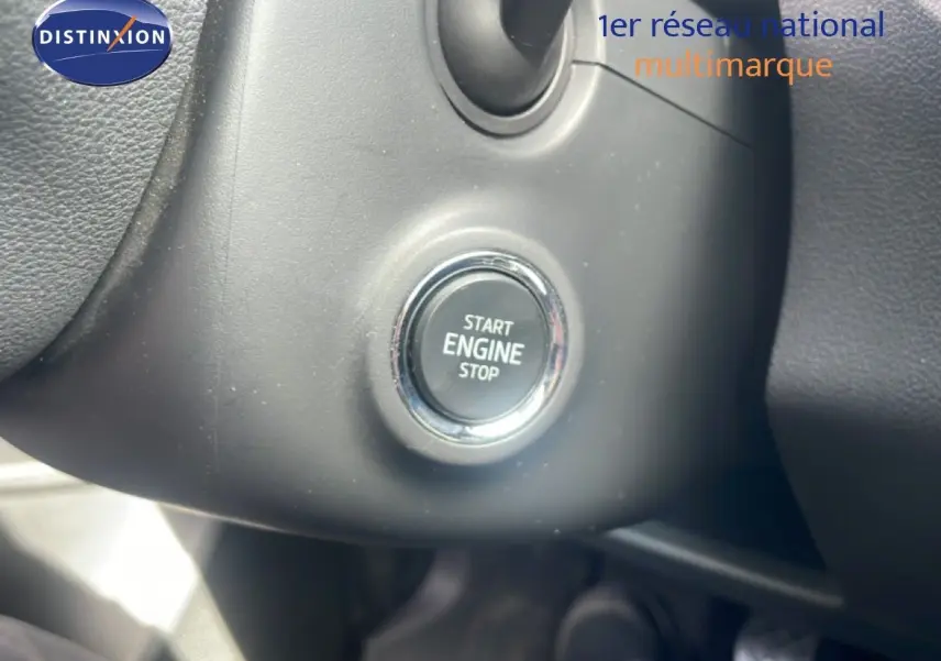 Gros plan sur le bouton Start Engine Stop noir entouré de chrome dans l'habitacle d'une Skoda Fabia blanche.
