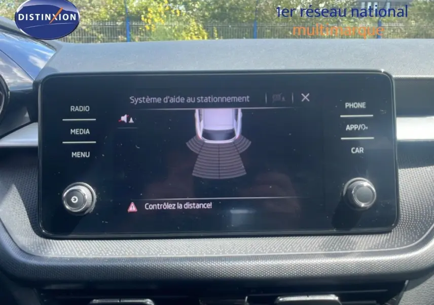 Écran tactile central du système d’aide au stationnement dans une Skoda Fabia blanche, vue intérieure frontale.