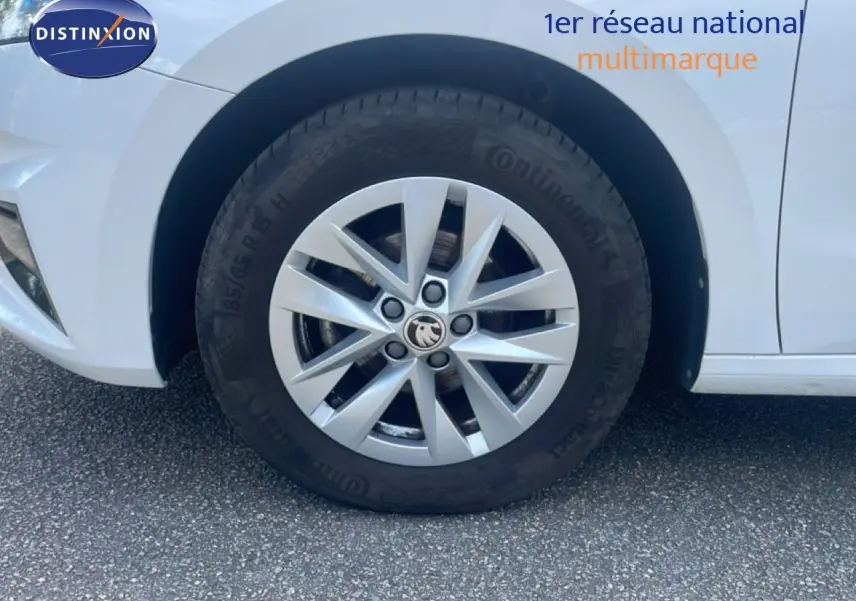 Gros plan sur la roue avant gauche d'une Skoda Fabia blanche Candy, mettant en valeur la jante alliage 15 pouces.