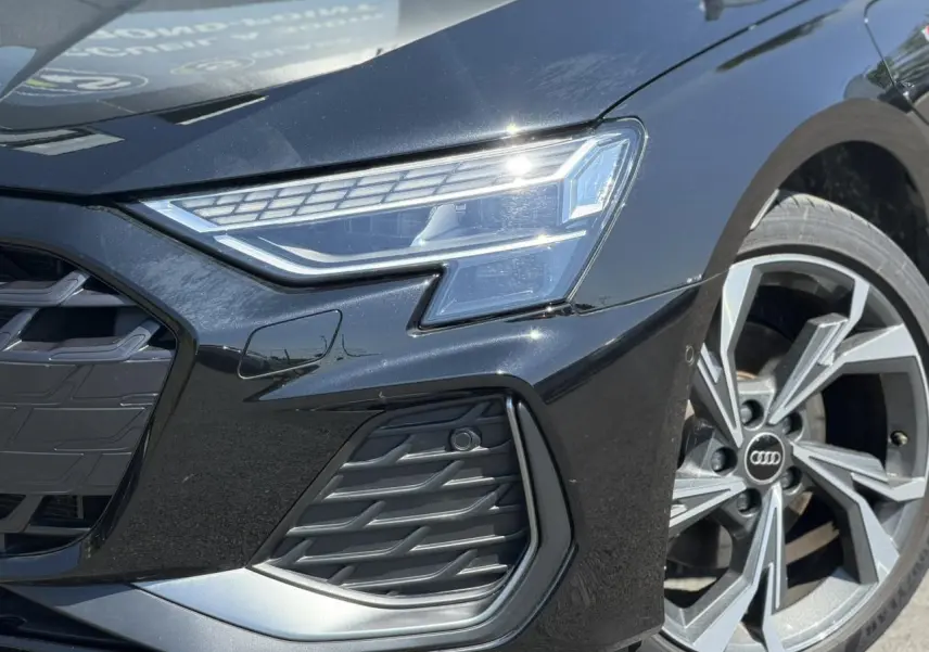 Gros plan avant droit de l'Audi A3 Sportback noir Mythe, mettant en valeur le phare Matrix LED et la jante alliage 5 branches en Y.