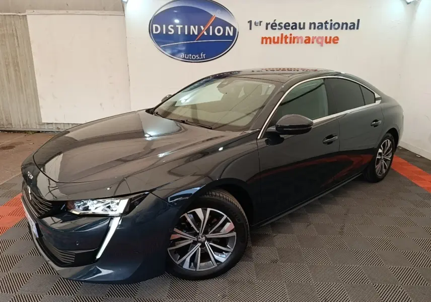 Peugeot 508 gris foncé vue 3/4 avant droit, avec feux LED et jantes alliage distinctives.