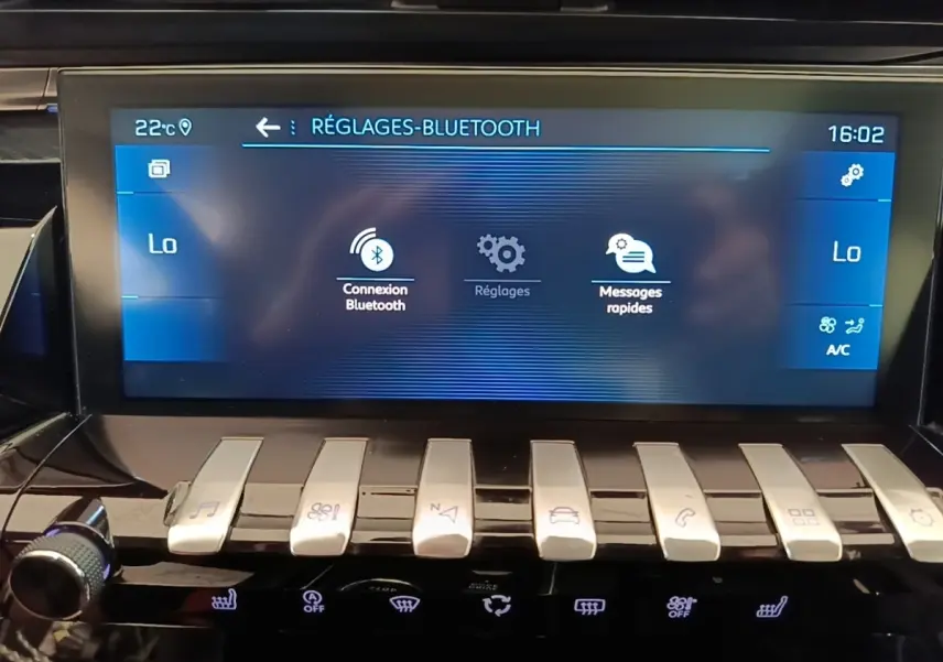 Gros plan sur l’écran tactile central et les commandes piano argentées du tableau de bord de la Peugeot 508 gris foncé.
