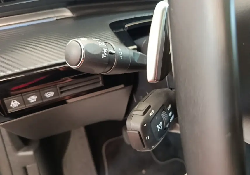 Gros plan sur la commande multifonction et la manette d’essuie-glace du tableau de bord intérieur d’une Peugeot 508 gris foncé.