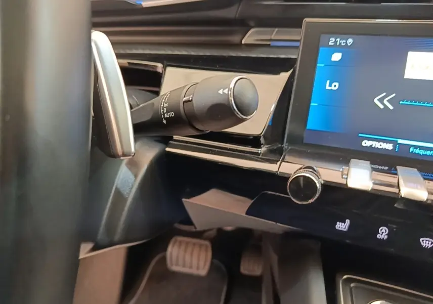 Gros plan intérieur sur la commande de clignotant et l’écran tactile du tableau de bord noir de la Peugeot 508 gris foncé.