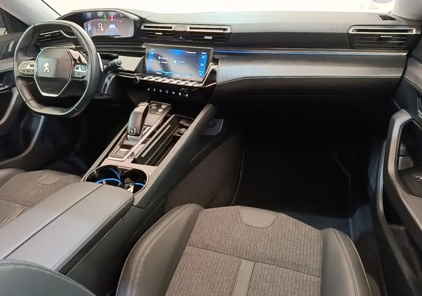 Vue intérieure avant droite du Peugeot 508 gris foncé, avec tableau de bord numérique et écran tactile central lumineux.