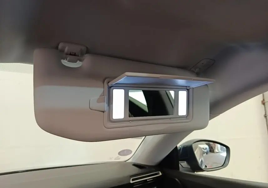 Détail du pare-soleil avec miroir éclairé à l'intérieur d'une Peugeot 508 gris foncé, vue côté conducteur.