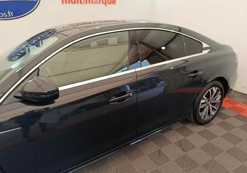Profil droit de la Peugeot 508 gris foncé, mettant en valeur les jantes alliage et les vitres teintées.