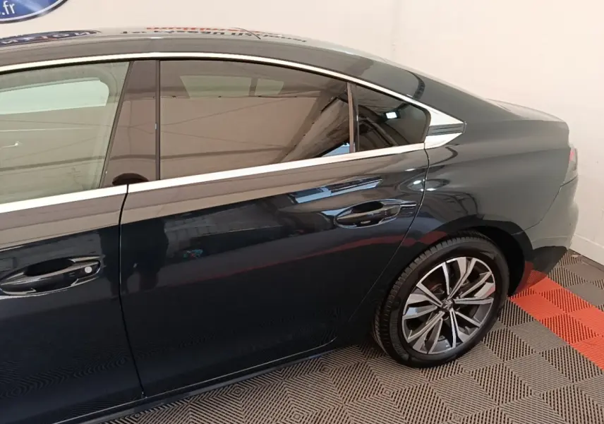 Vue latérale côté droit d'une Peugeot 508 gris foncé avec jantes alliage et vitres teintées.