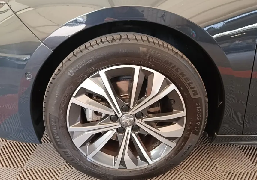 Gros plan sur la roue avant gauche de la Peugeot 508 gris foncé, jante alliage à design moderne et pneus Michelin.