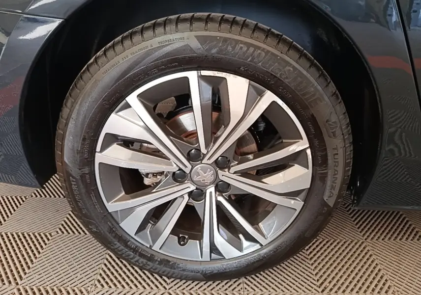 Gros plan sur la roue avant droite d'une Peugeot 508 gris foncé avec jante alliage à multiples branches.