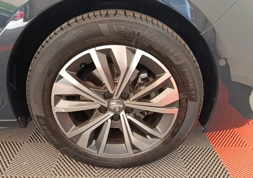 Gros plan sur la roue avant droite gris foncé d'une Peugeot 508 avec jante alliage à motifs en étoile.