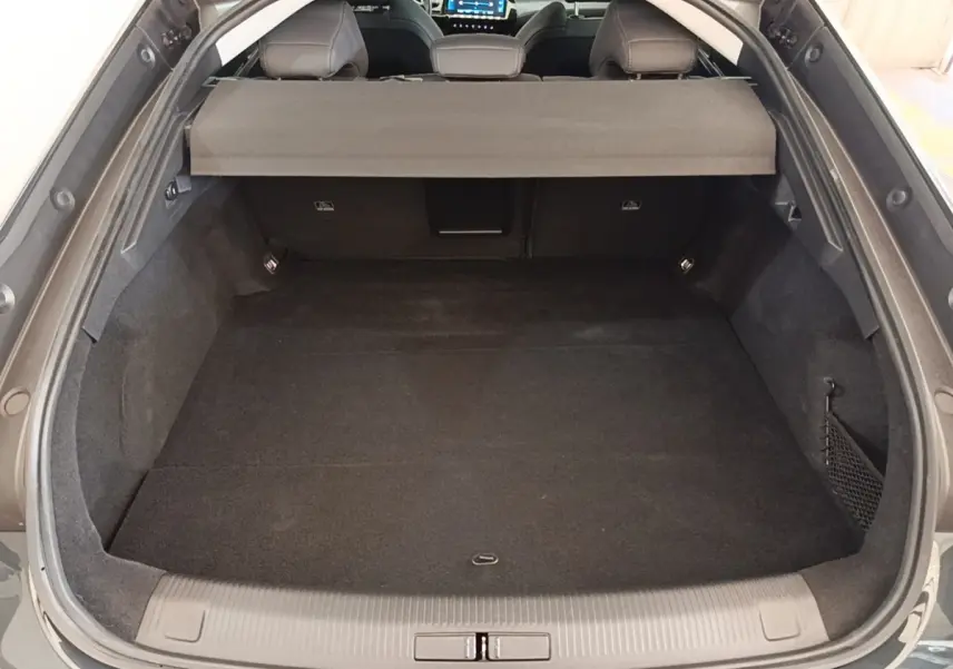 Coffre ouvert vu de l'arrière d'une Peugeot 508 gris foncé avec banquette arrière et cache-bagages visibles.
