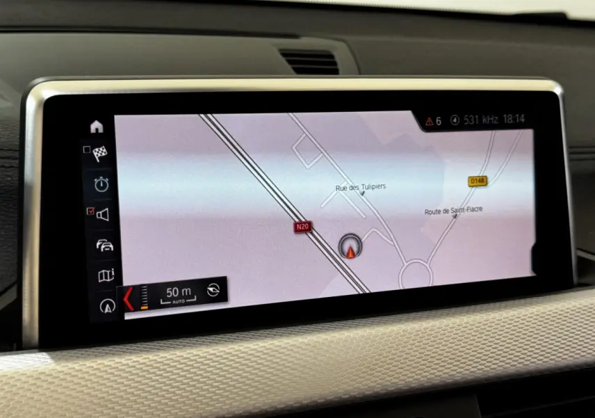 Écran central du système de navigation 3D couleur dans l’habitacle du BMW X2 blanc, vue rapprochée.