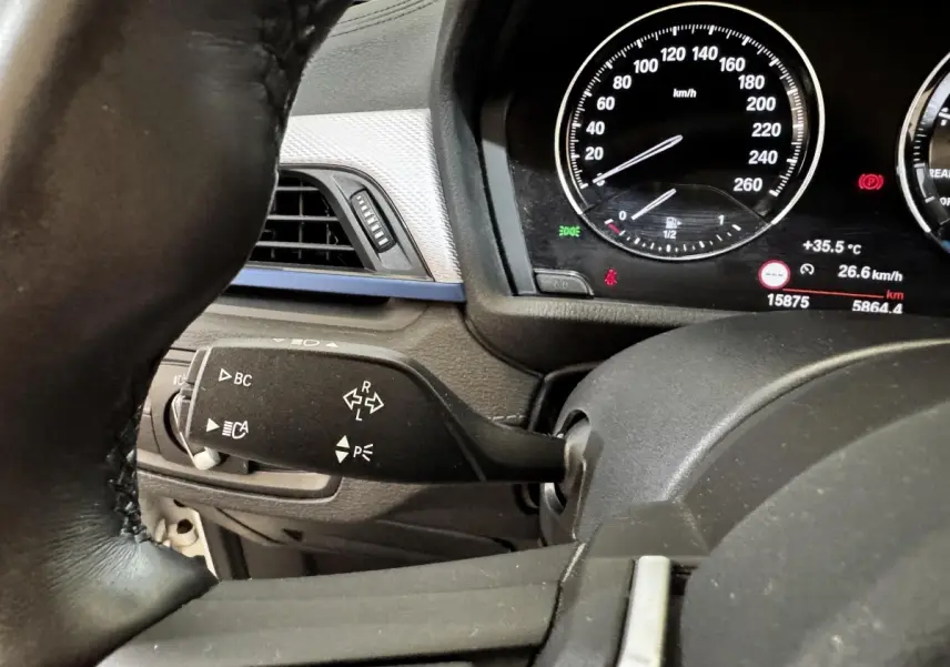 Gros plan intérieur sur le combiné d'instruments et la commande de clignotants du BMW X2 blanc xDrive25e M Sport 2022.