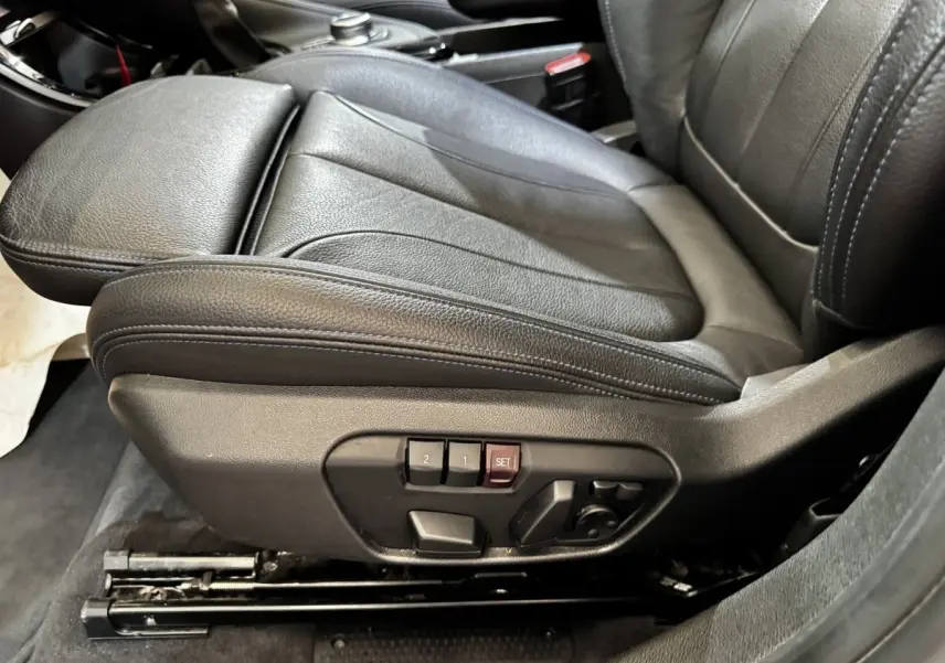 Gros plan sur le siège conducteur en cuir noir avec commandes électriques de la BMW X2 xDrive25e M Sport 2022.