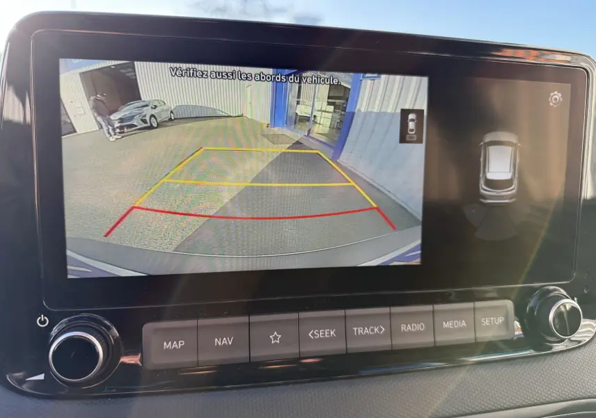 Écran de caméra de recul du Hyundai Kona blanc Atlas 2021 affichant une vue arrière avec lignes de guidage colorées.