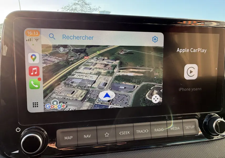 Écran tactile du système multimédia du Hyundai Kona blanc, affichant la navigation Google Maps et Apple CarPlay.