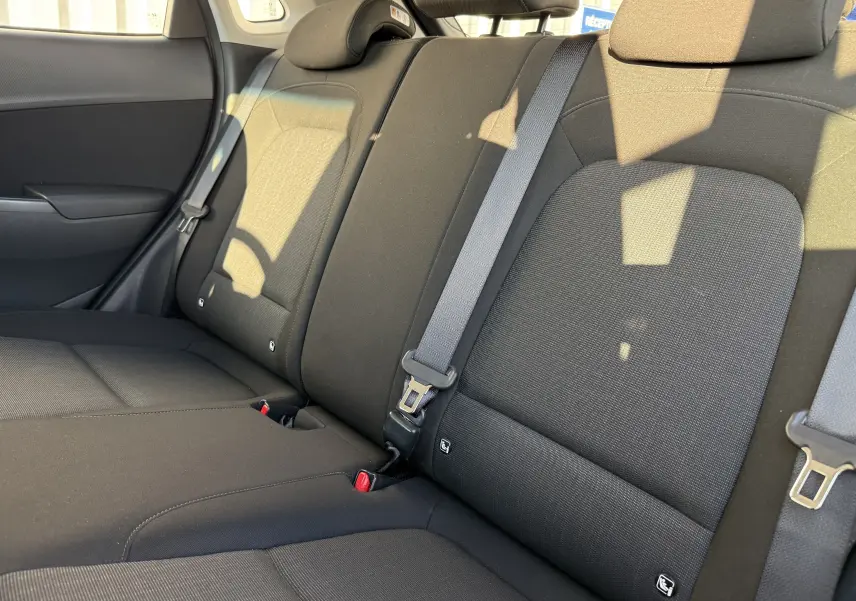 Vue rapprochée des sièges arrière en tissu gris noir du Hyundai Kona 2021 avec ceintures de sécurité visibles.