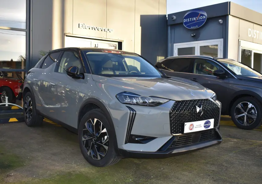 DS3 Crossback gris clair vue 3/4 avant droit, avec calandre noire à motifs losanges et toit noir contrasté.