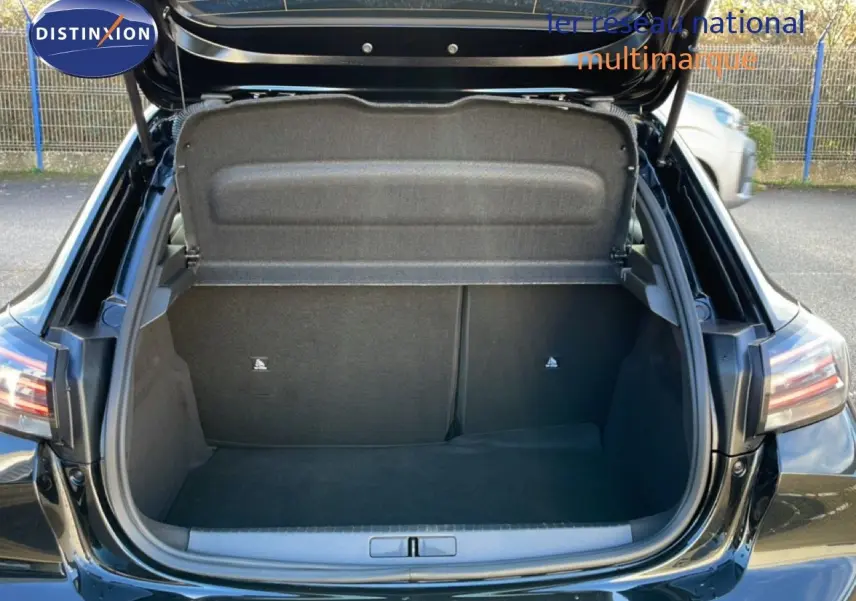Coffre ouvert vu de l'arrière d'une Peugeot 208 noire 2025, montrant un espace de chargement vide et propre.