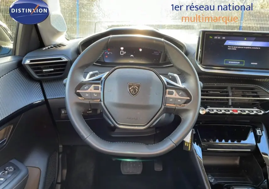 Vue intérieure centrée sur le volant noir de la Peugeot 208 1.2 Hybrid 110ch avec tableau de bord digital et écran tactile.