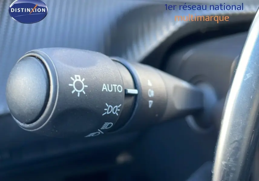 Gros plan sur la commande d’éclairage automatique dans l’habitacle d’une Peugeot 208 noire 2025.