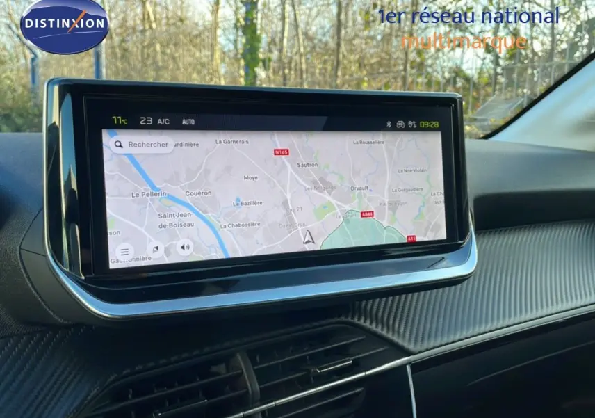 Écran tactile central affichant la navigation GPS dans l'habitacle noir de la Peugeot 208 hybride 2025.