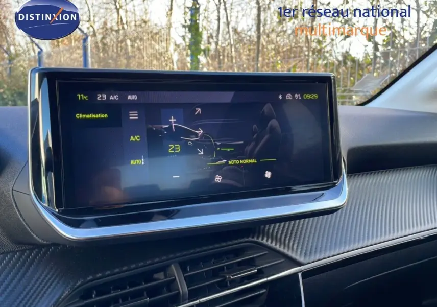 Vue rapprochée de l'écran tactile central affichant la climatisation dans l'habitacle gris noir d'une Peugeot 208 noire 2025.