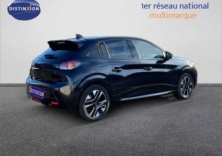 Vue 3/4 arrière droite d'une Peugeot 208 noire 2025 avec jantes alliage et toit noir brillant.