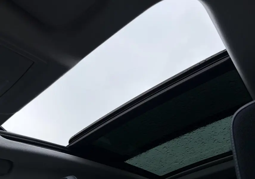 Vue intérieure du toit ouvrant panoramique vitré noir du Citroën C5 Aircross Platinium 2026 avec ciel gris visible.