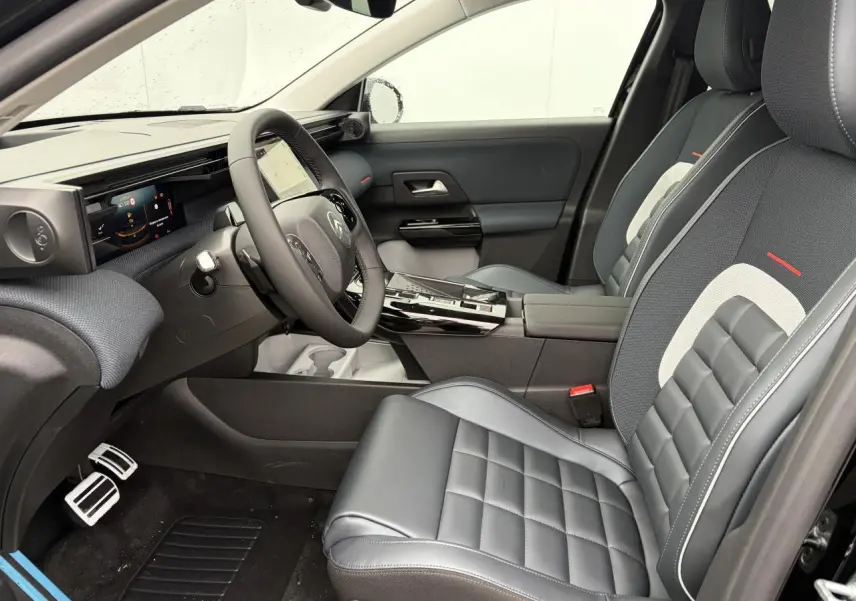 Vue intérieure côté conducteur du Citroën C5 Aircross 2026, sièges cuir et tissu gris avec surpiqûres blanches et rouges.